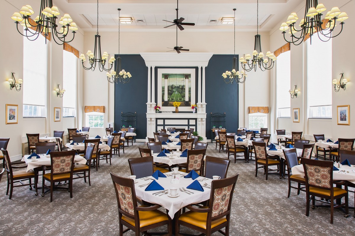 An elegant dining room with neatly arranged tables and chandeliers creating a sophisticated atmosphere.