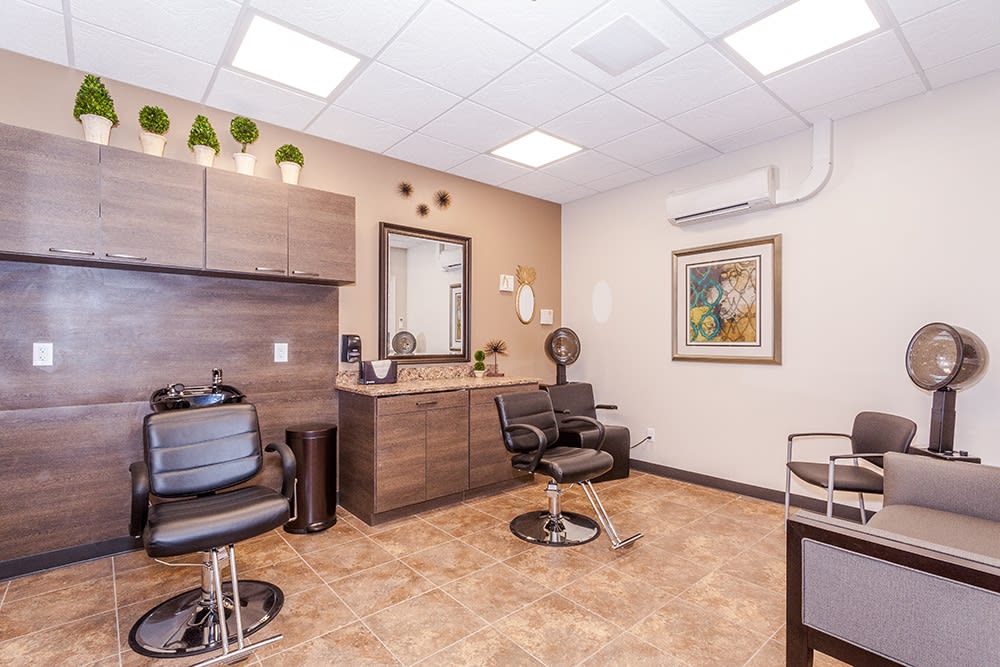A modern and clean hair salon interior with chairs, a mirror, and stylish decor.