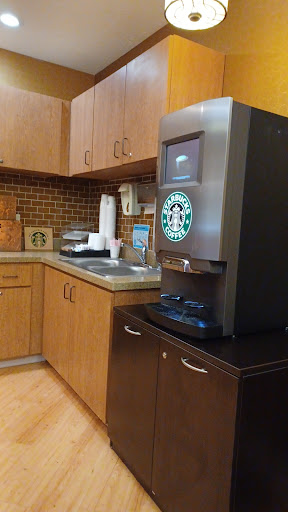 A coffee station featuring a Starbucks coffee machine in a cozy kitchen setting.