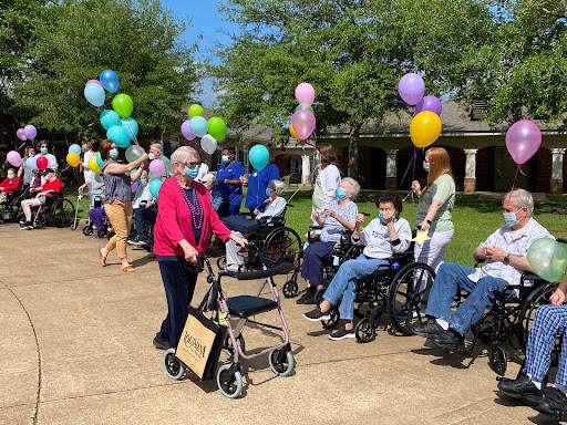 Seniors enjoying a joyful outdoor celebration with colorful balloons.