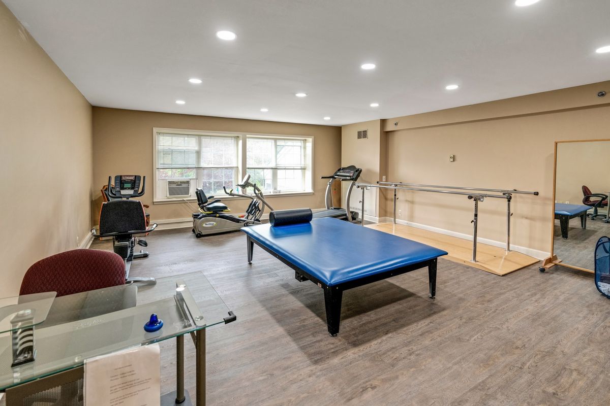 A versatile home recreation room featuring exercise equipment and a ping pong table.