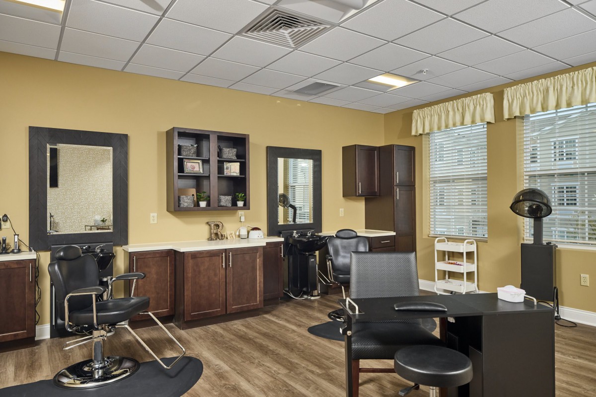 A modern hair salon interior with styling stations and seating.