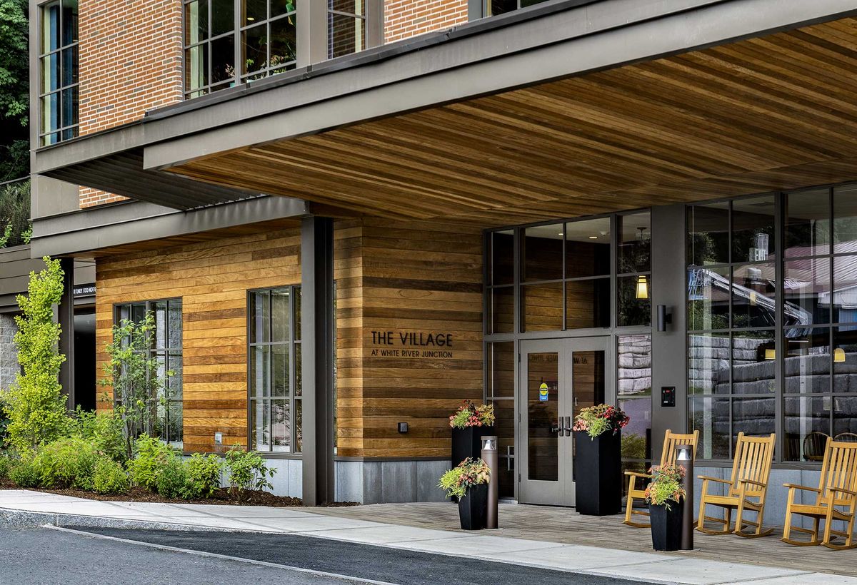 Modern building entrance with wood paneling and potted plants.