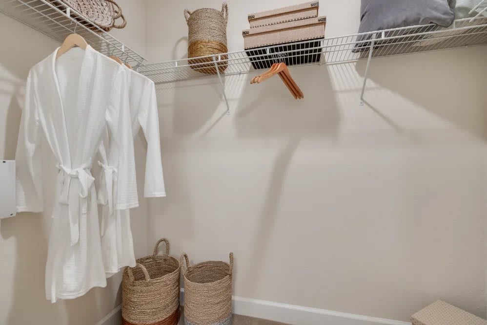 A neatly organized closet with baskets, shelves, and hangers.