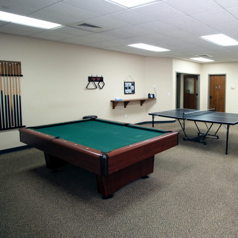 A spacious game room featuring a pool table and a ping pong table.