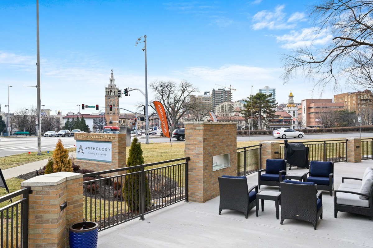A view of a cityscape with outdoor seating and buildings in the background under a clear blue sky.