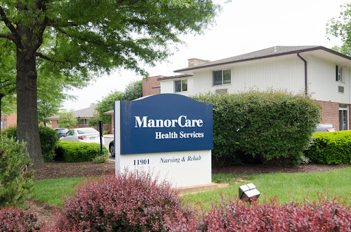 A sign indicating the location of ManorCare Health Services, set in a landscaped area.