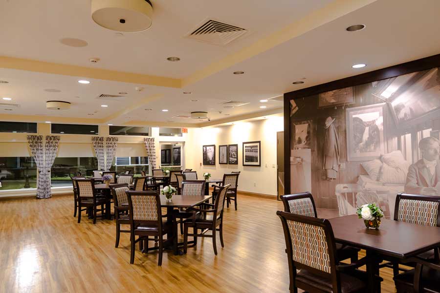 A spacious and elegantly designed restaurant dining area with wooden floors and neatly arranged tables and chairs.