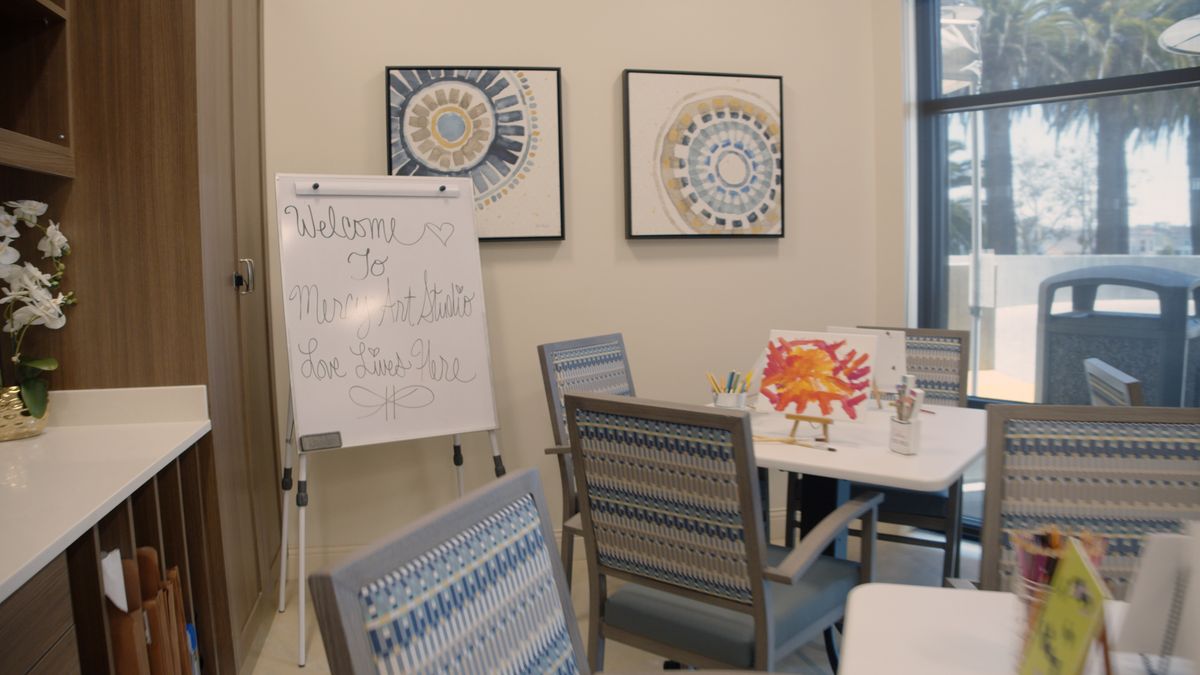 A meeting room with a whiteboard, chairs, and decorative artwork on the walls.