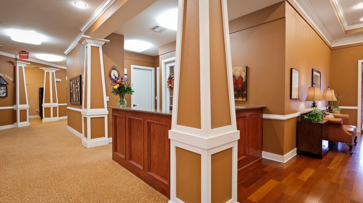 A welcoming reception area with a wooden counter and decorative columns.