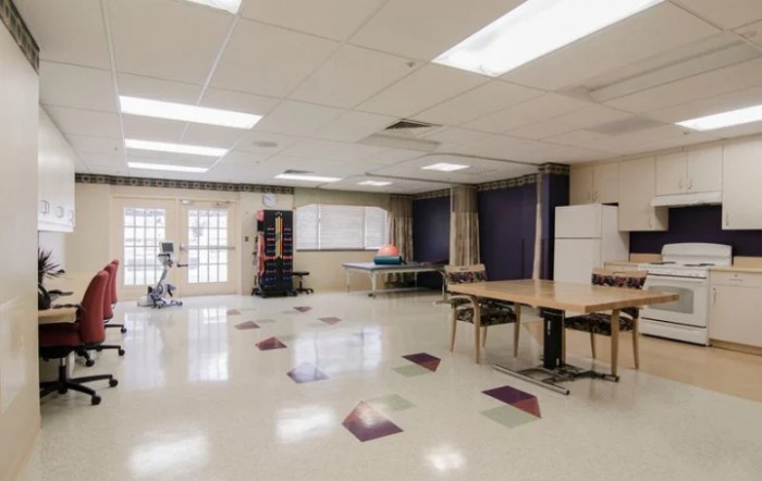 A spacious community recreation room with tables, chairs, and a ping pong table.