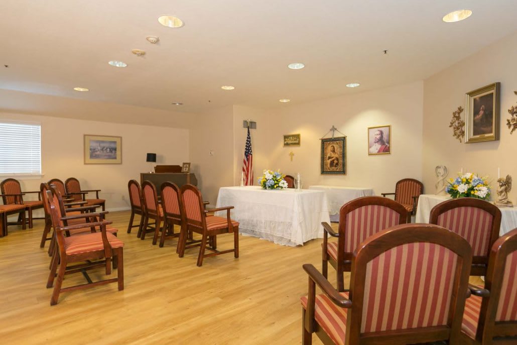 A small ceremony room with arranged chairs, a podium, and a flag.