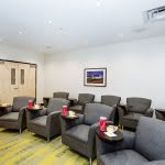 A modern waiting room featuring comfortable chairs and a clean design.