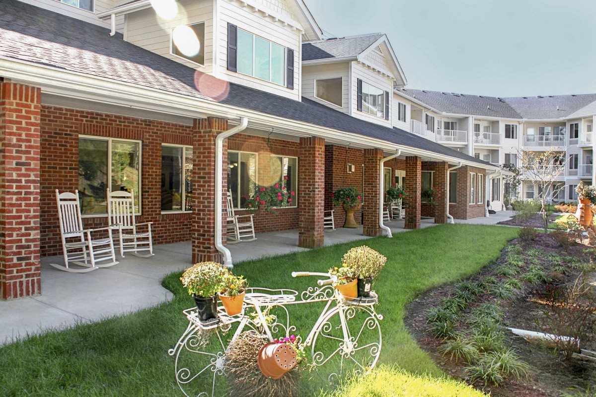 A charming retirement home with a beautifully landscaped garden featuring a decorative bicycle planter.