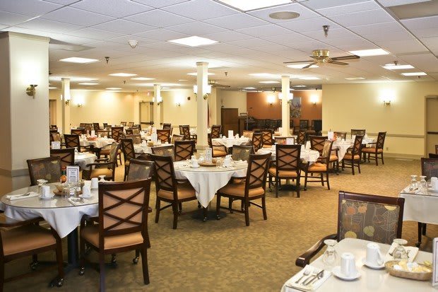 An empty dining room with neatly arranged tables and chairs, ready for guests.