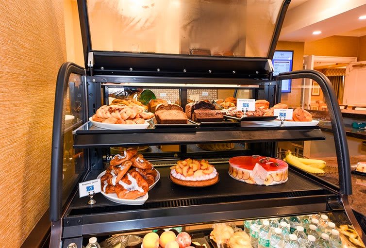 A bakery display case filled with a variety of pastries and cakes.