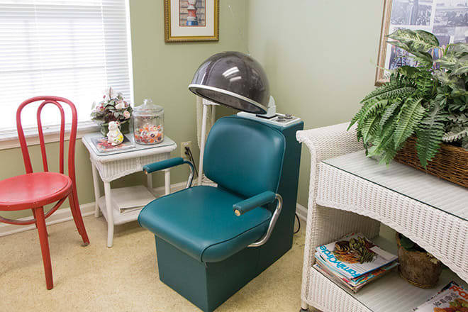 A vintage salon setup featuring a classic hair dryer and teal chair.