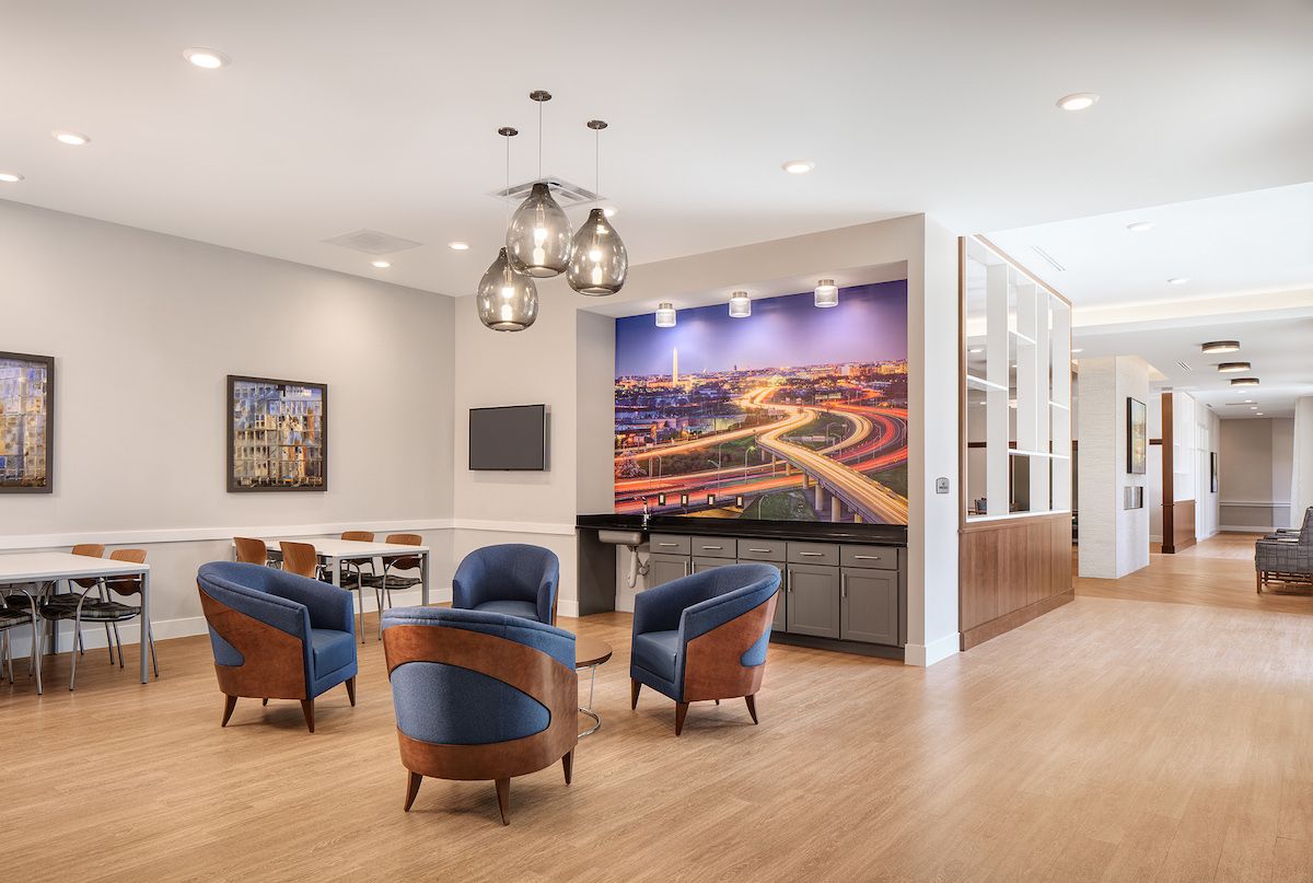 A modern lounge area featuring comfortable seating, contemporary artwork, and elegant lighting.