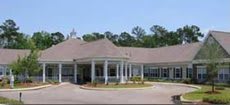 Front view of a commercial building with a large entrance and surrounding landscape.