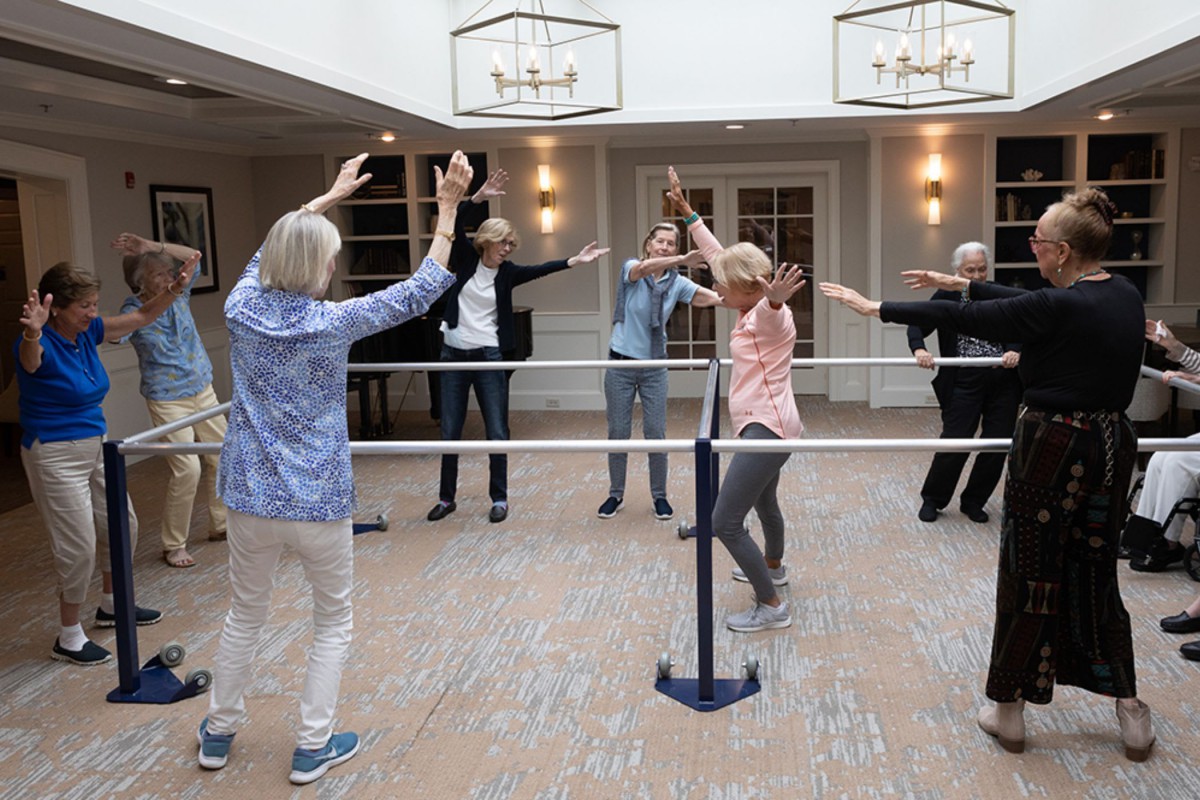 A group of senior citizens participating in an indoor exercise class.