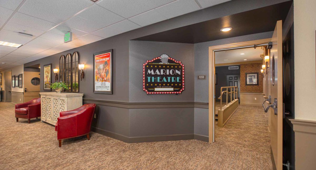 Interior of a movie theater with a classic marquee sign and vintage posters.