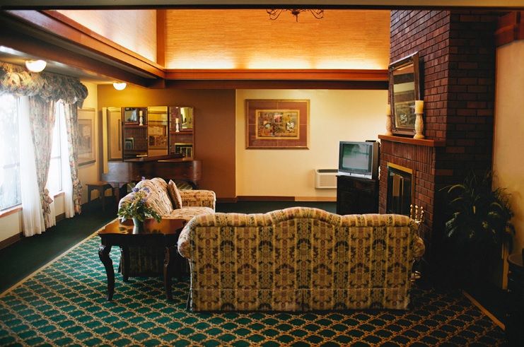 A cozy vintage-style living room with a patterned sofa, coffee table, and an old television set.