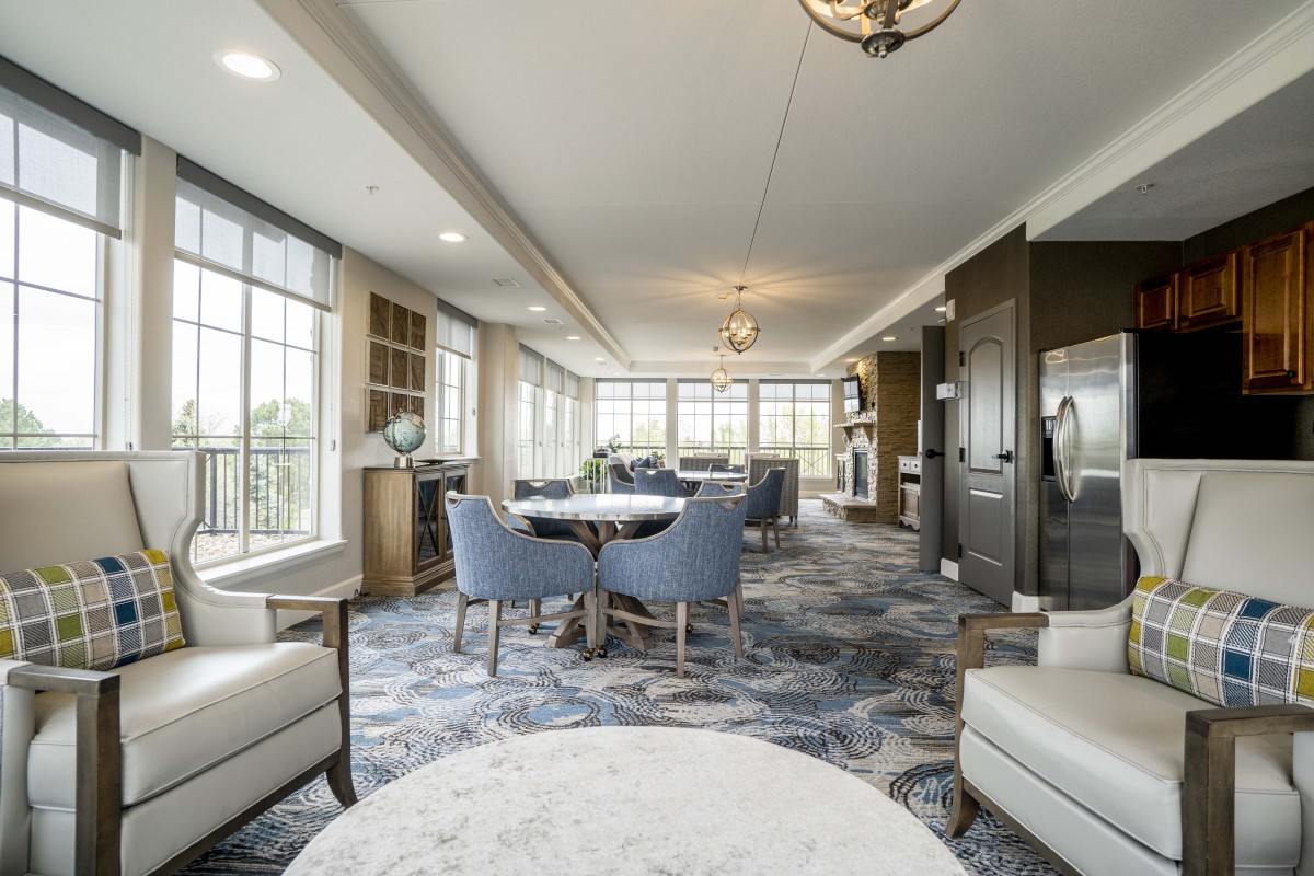 A modern living room with ample seating and large windows offering natural light.