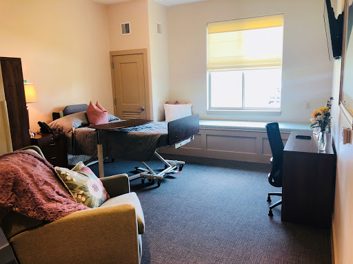 A spacious room featuring a bed, a desk, and cozy seating options.