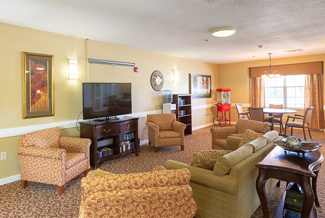 A cozy living room with comfortable seating, a large television, and a popcorn machine.
