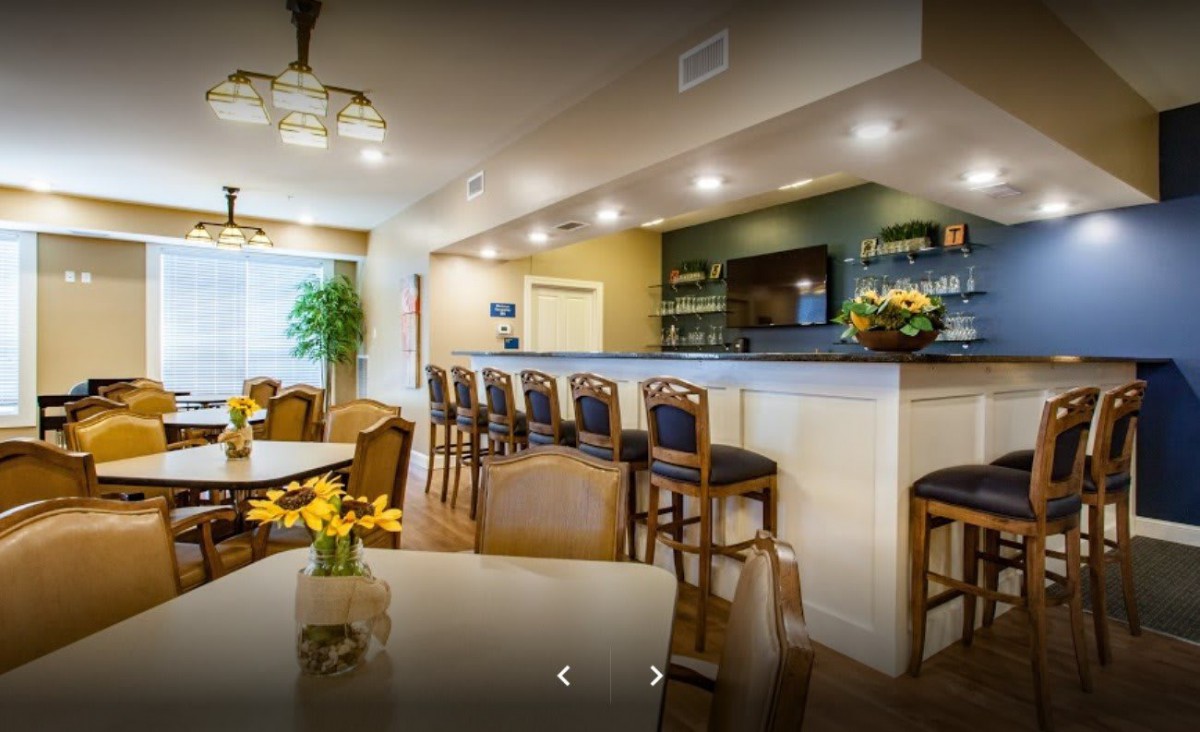 A cozy dining area with a bar and stylish seating, featuring elegant lighting and decor.