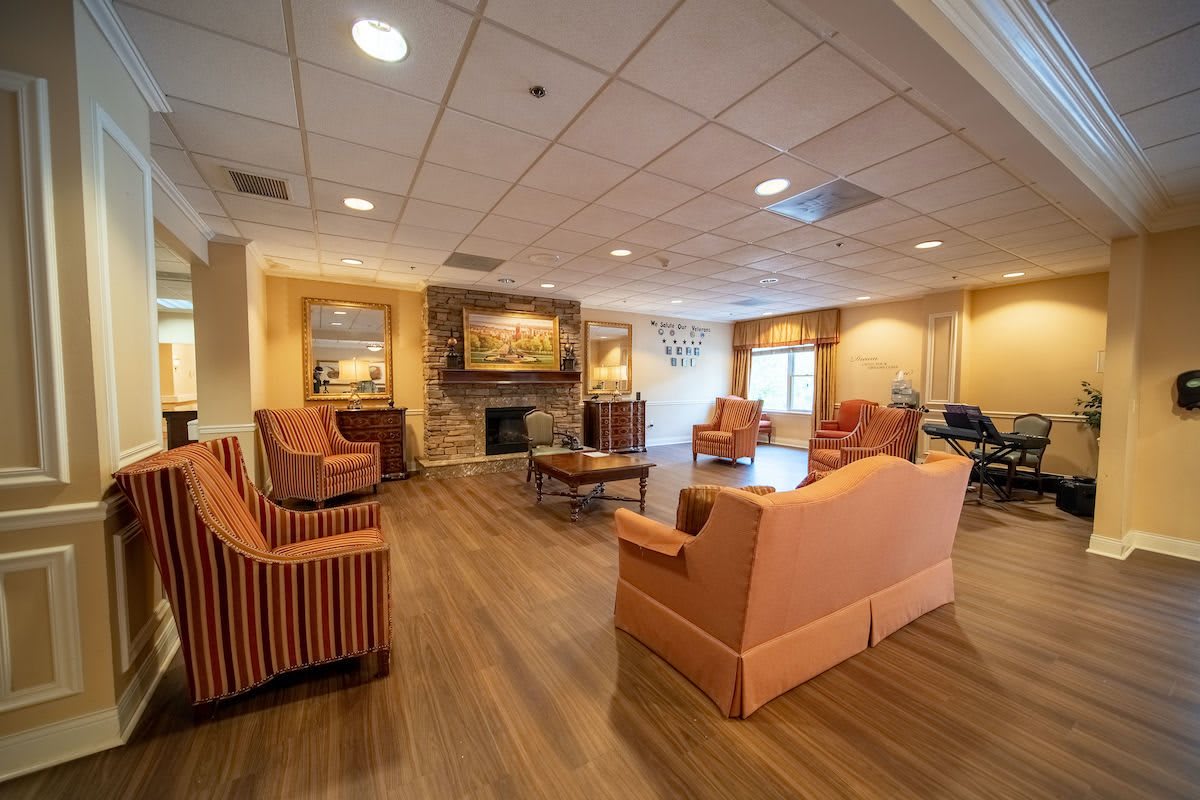 A cozy living room with armchairs and a fireplace, featuring warm lighting and modern decor.