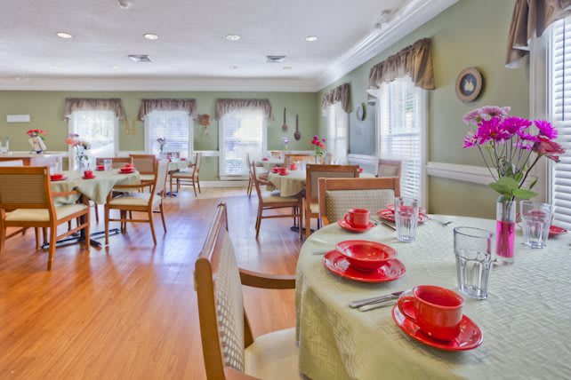 A neatly arranged dining room with tables set for a meal.