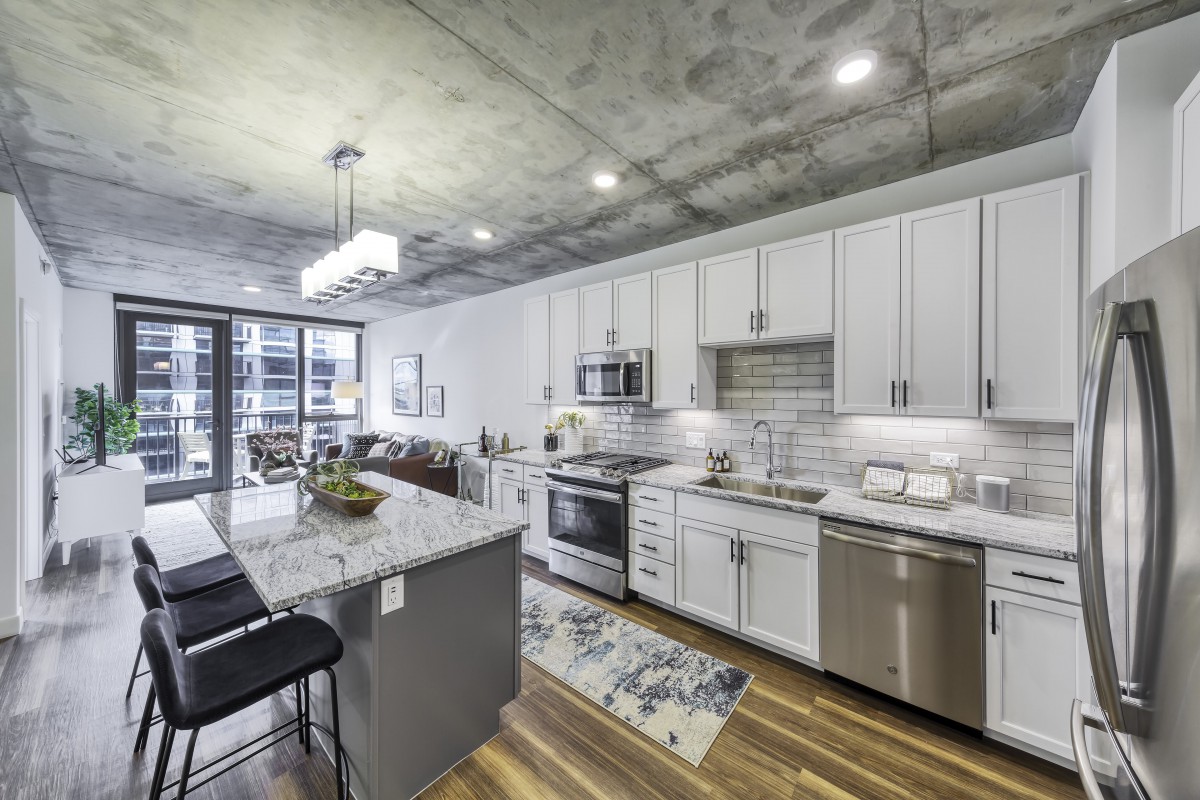 A modern kitchen with white cabinets, stainless steel appliances, and a spacious island.