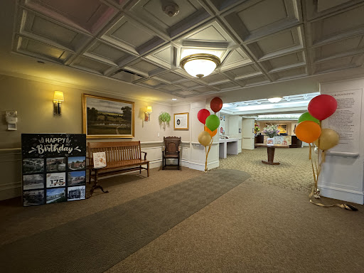 A spacious lobby decorated for an event, featuring seating and colorful balloons.