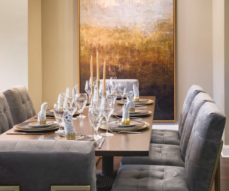 A beautifully set dining table with elegant decor and artwork on the wall.