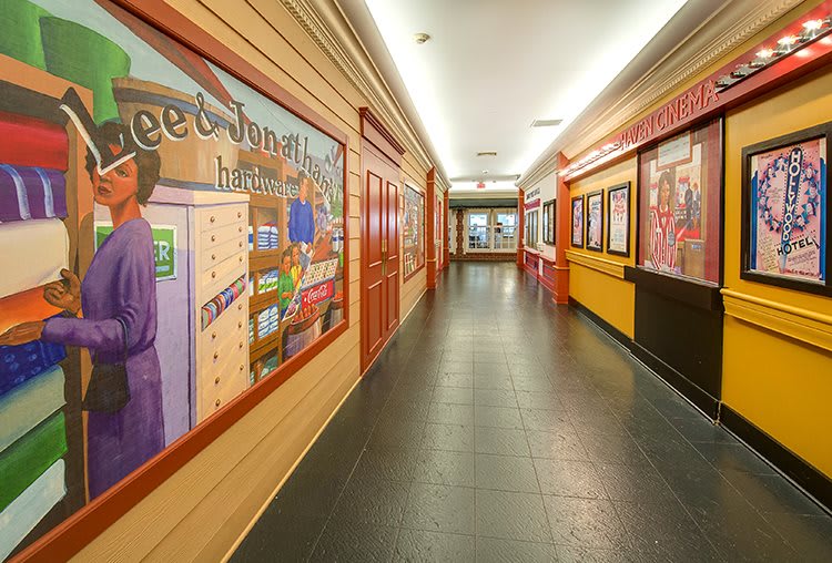 A colorful hallway adorned with murals on both sides.