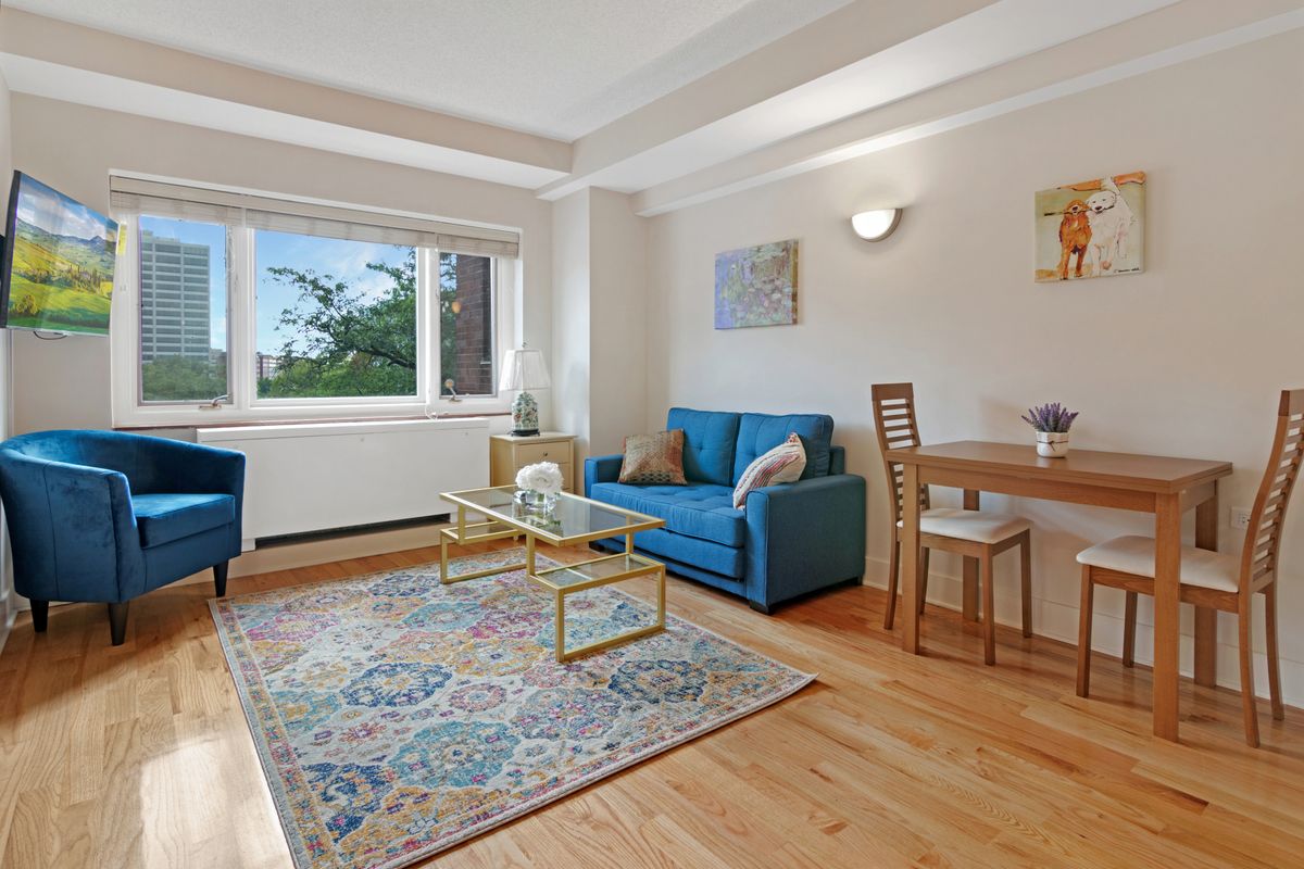 A bright and cozy living room with blue furniture and elegant decor.