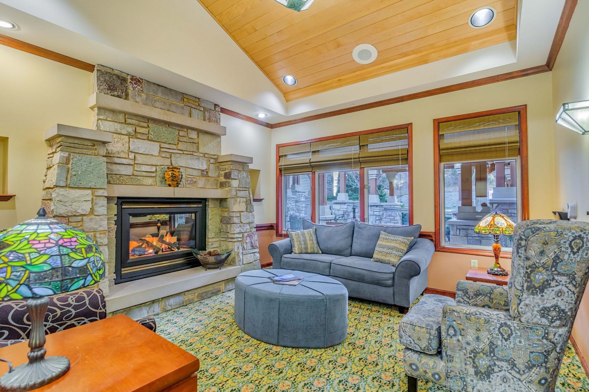 A cozy living room with a stone fireplace and comfortable seating.