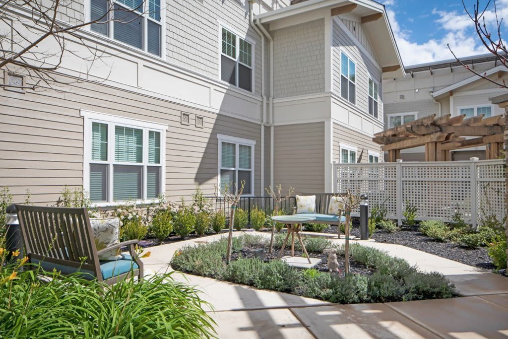 A modern apartment complex featuring a landscaped courtyard with outdoor seating.