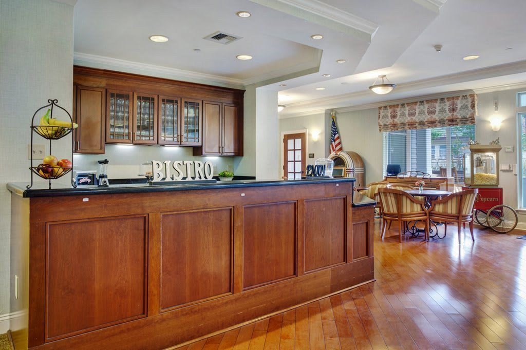 A cozy bistro-style kitchen with wooden cabinetry and a dining area.