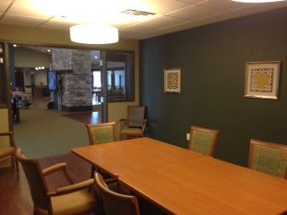 A conference room with a wooden table and chairs, suitable for meetings.