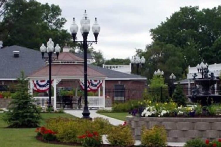A scenic park with a gazebo, lampposts, and colorful landscaping.