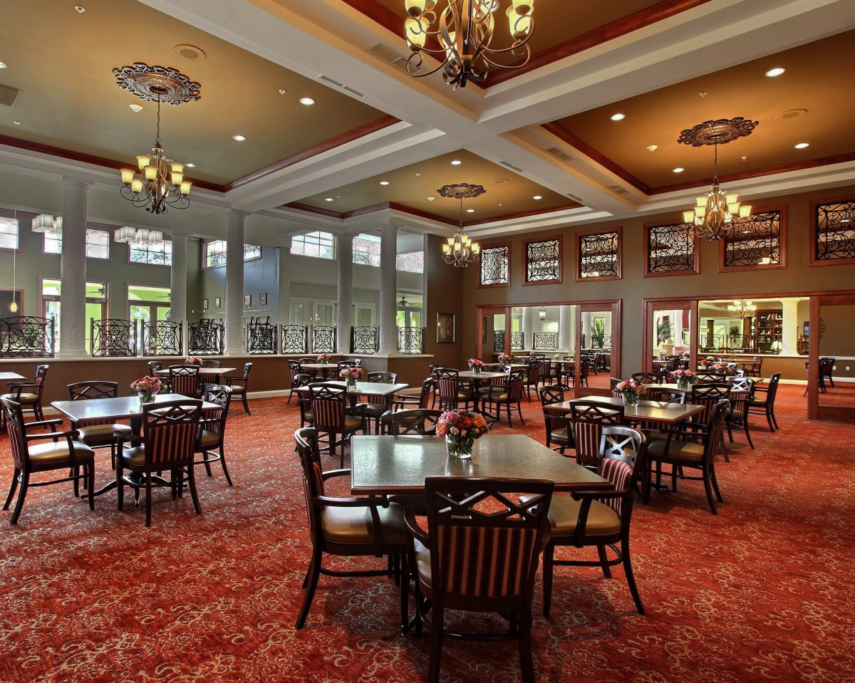 Spacious dining hall with elegant chandeliers and large windows.