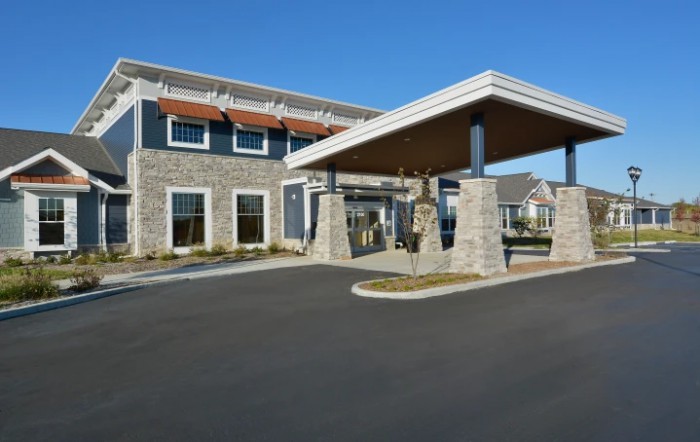 A modern building with a stone facade and covered entrance.