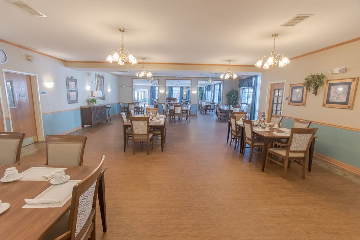 A spacious and elegantly designed dining room with neatly arranged tables and chairs.