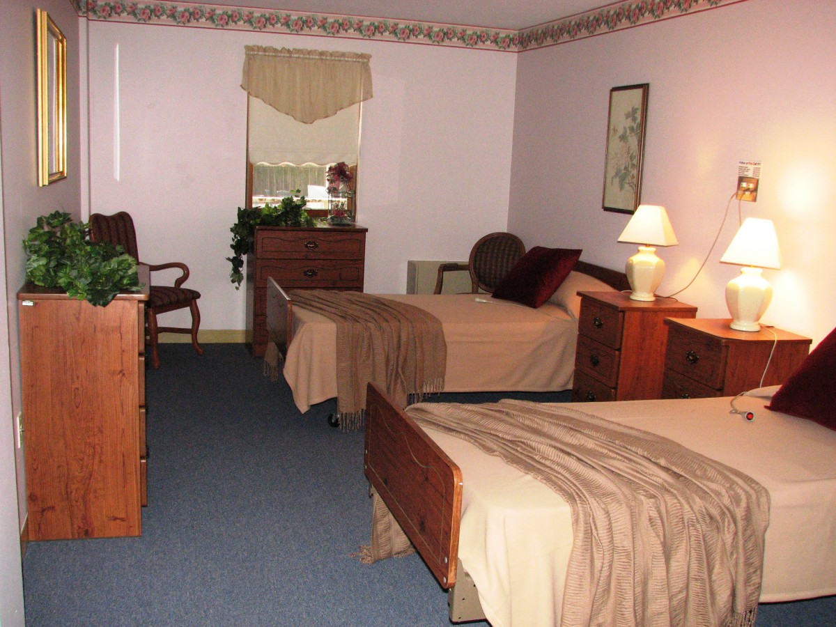 A cozy bedroom with two beds and classic wooden furniture.