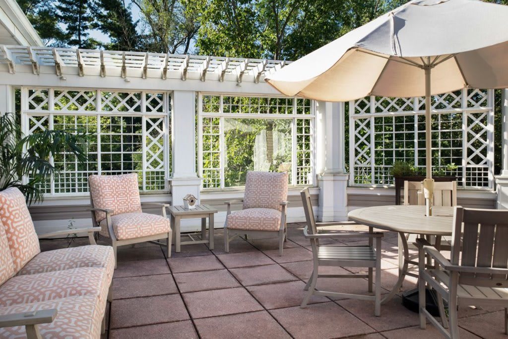 A cozy outdoor patio with comfortable seating and a large umbrella.