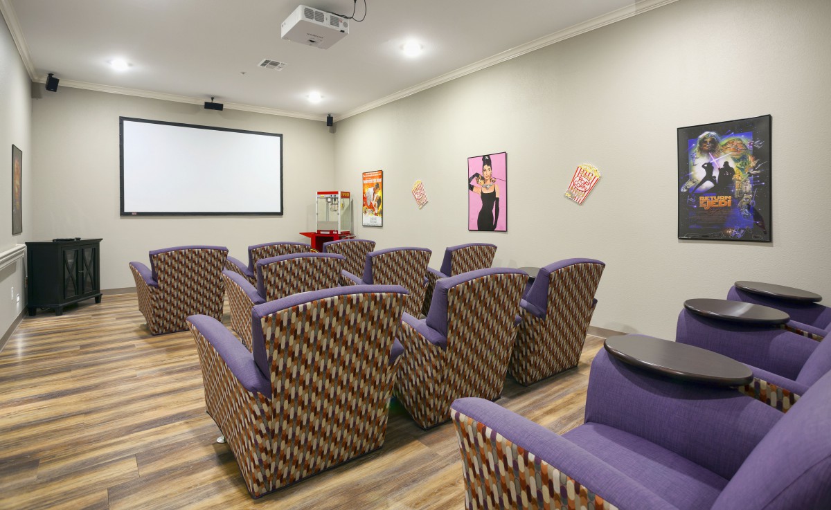 A cozy home theater room with comfortable seating and a large projector screen.