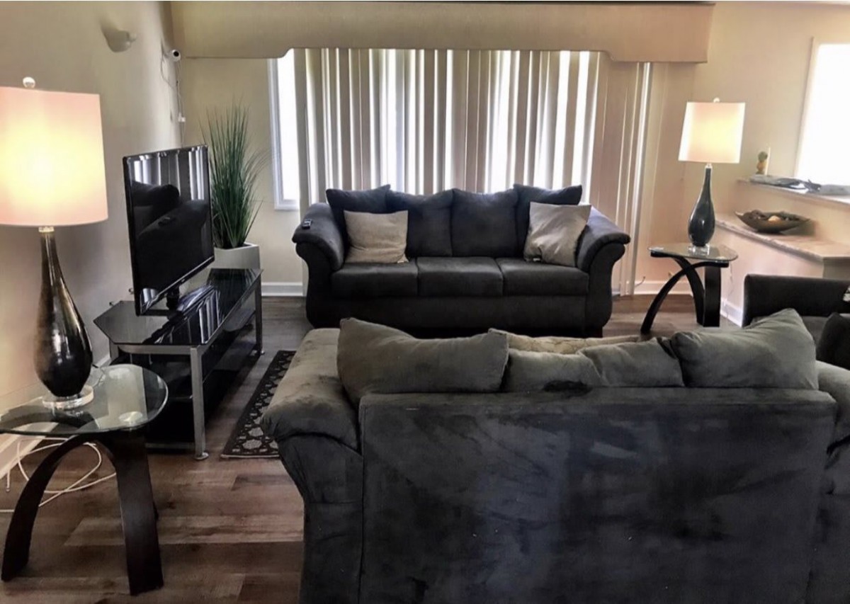 A cozy living room with sofas, a television, and tasteful decor.