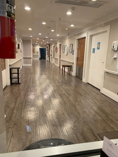 A well-lit interior hallway showcasing artwork and modern flooring.